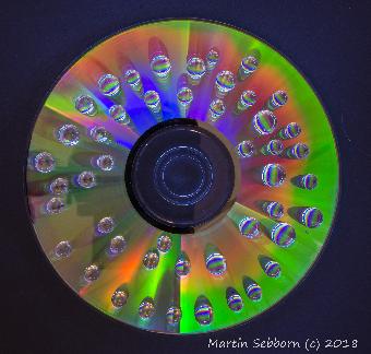 Water drops on CD illuminated by torch